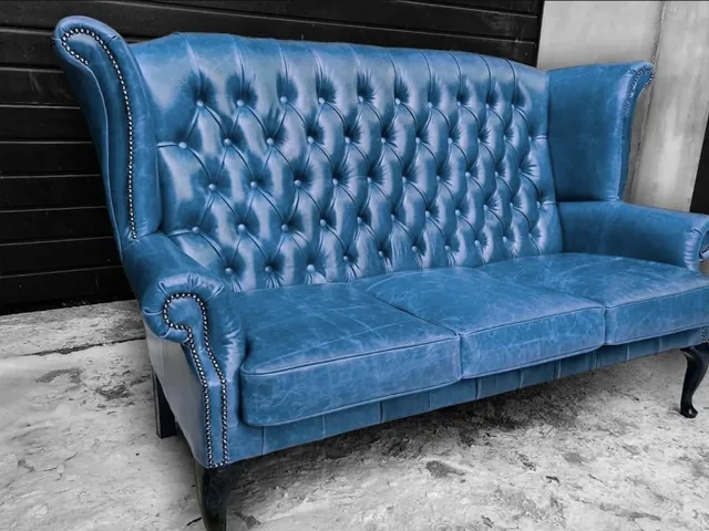 Wysoka sofa w niebieskiej tapicerce